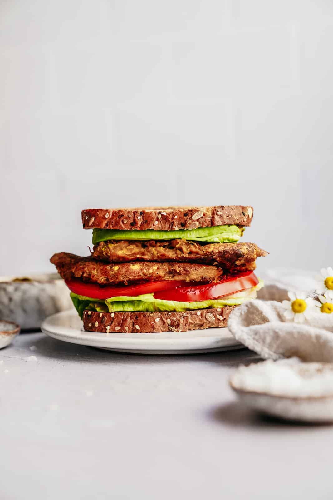 Vegan chickpea scramble on a breakfast sandwich stacked on a plate