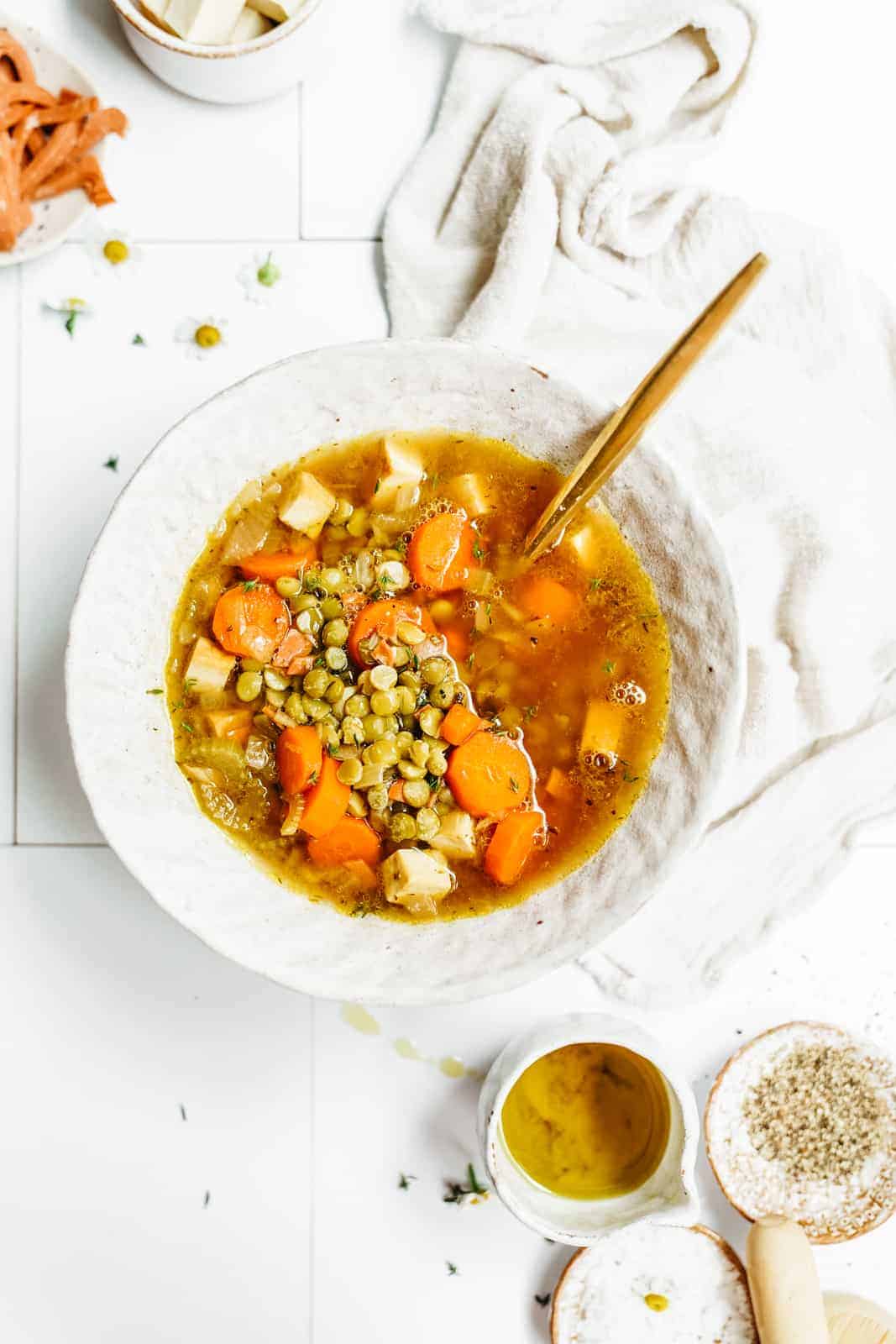 vegan split pea soup sitting on countertop with a spoon in the bowl.