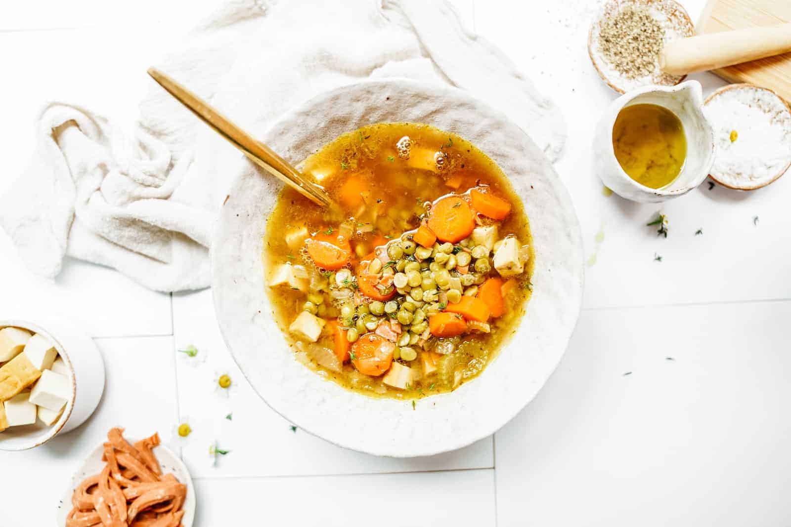 Soup Recipes you'll love: Split pea soup in a white dish surrounded by fresh ingredients
