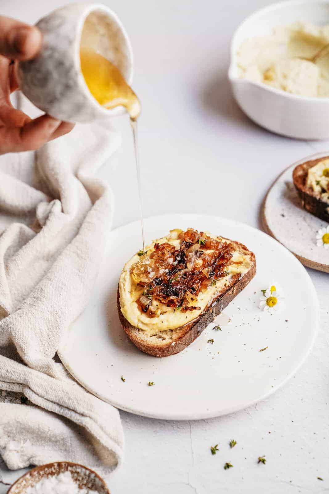 Honey pouring on ricotta toast to showcase the importance of movement in photography