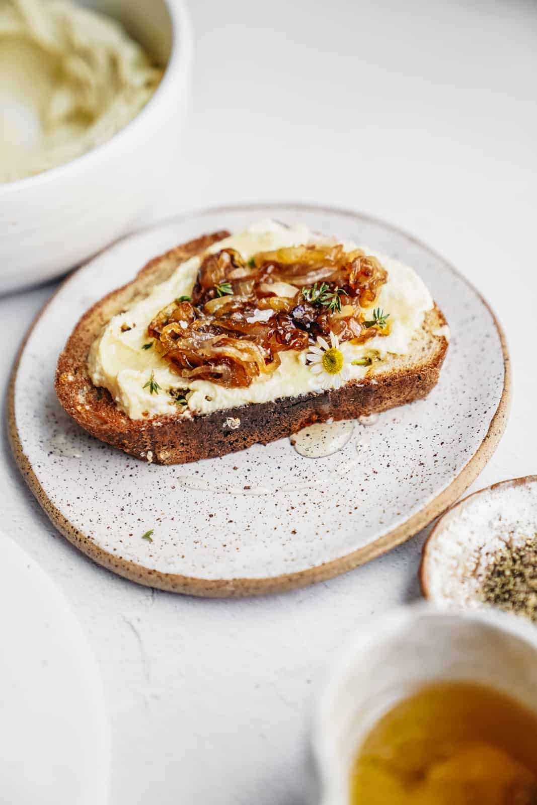 Cashew ricotta spread on toast with caramelized onions on top