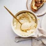 Close up of cashew ricotta in a bowl with a spoon