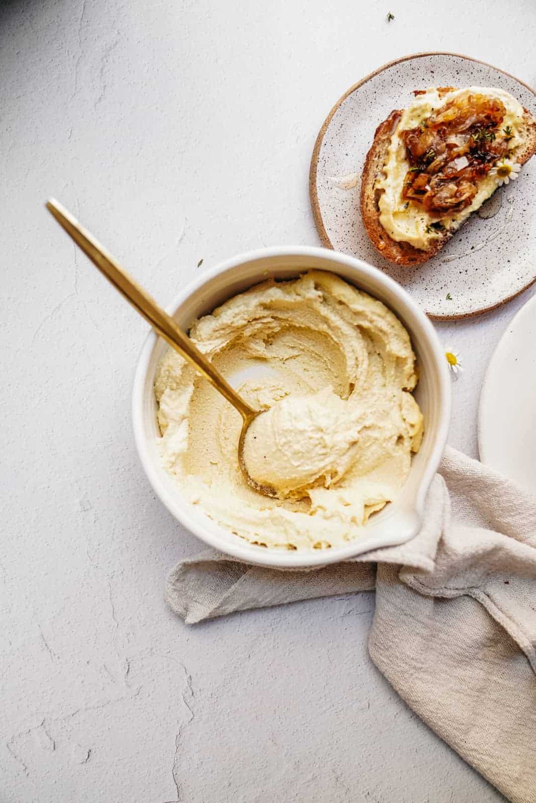 Close up of cashew ricotta in a bowl with a spoon