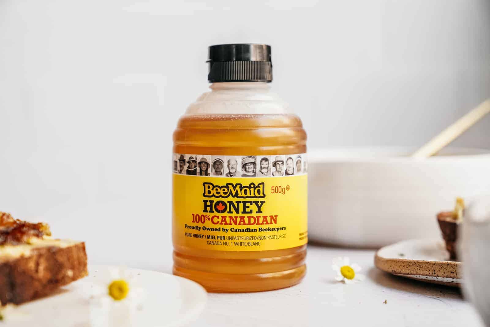 Container of Bee Maid Honey on countertop.