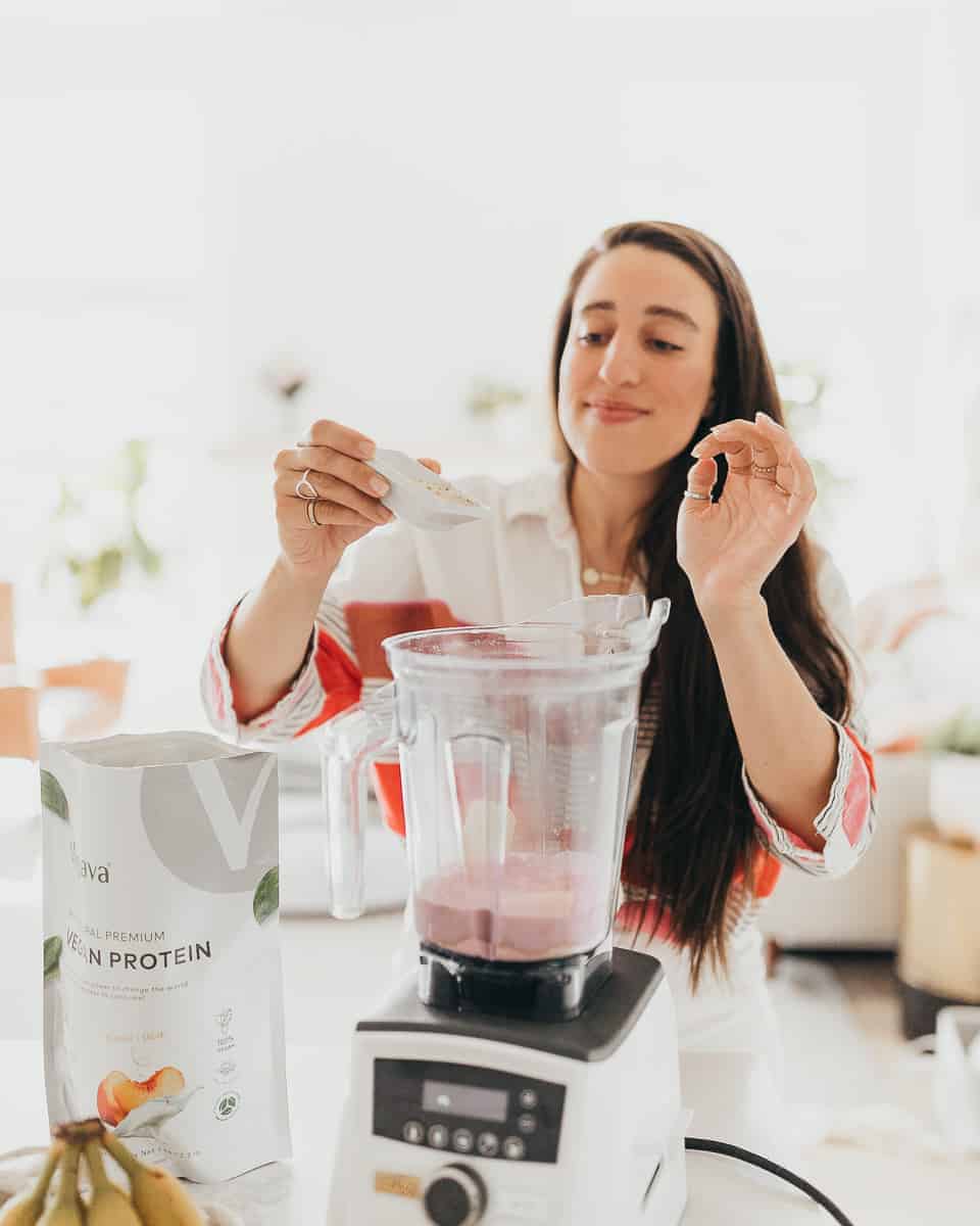 Maria using protein powder in her vegan protein smoothie