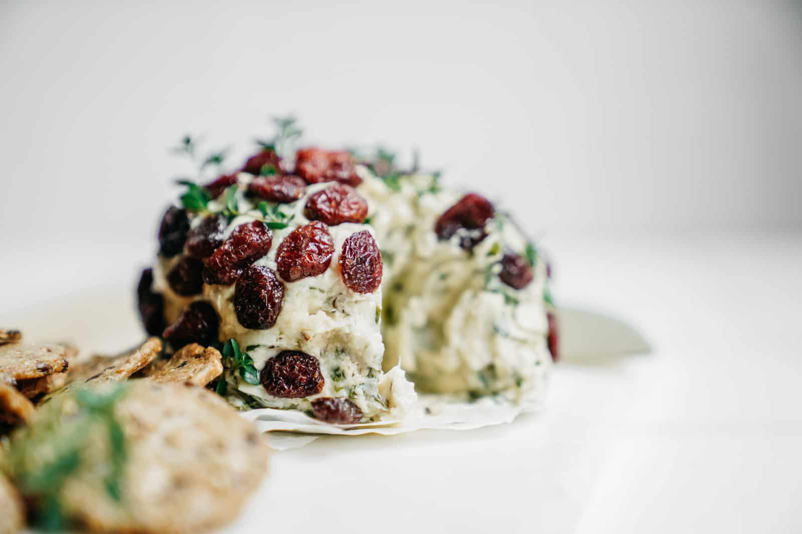 Close-up of a plant-based cheese ball on counter with crackers.