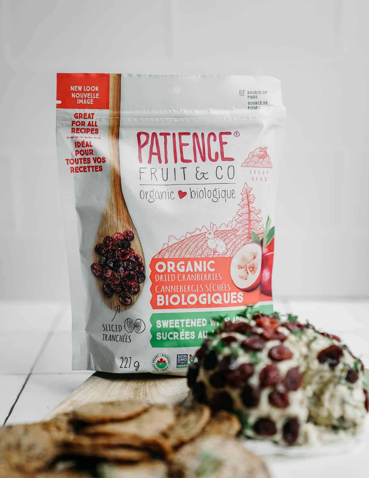 Patience Fruit & Co dried cranberries in the bag on a counter with a cheese ball and cracker on the side.
