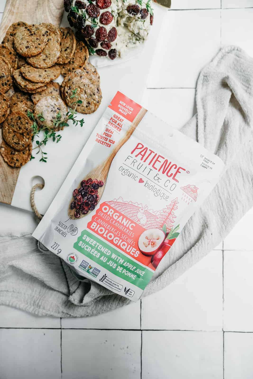 Patience Fruit & Co dried cranberries in the bag on a counter with a cheese ball and cracker on the side.