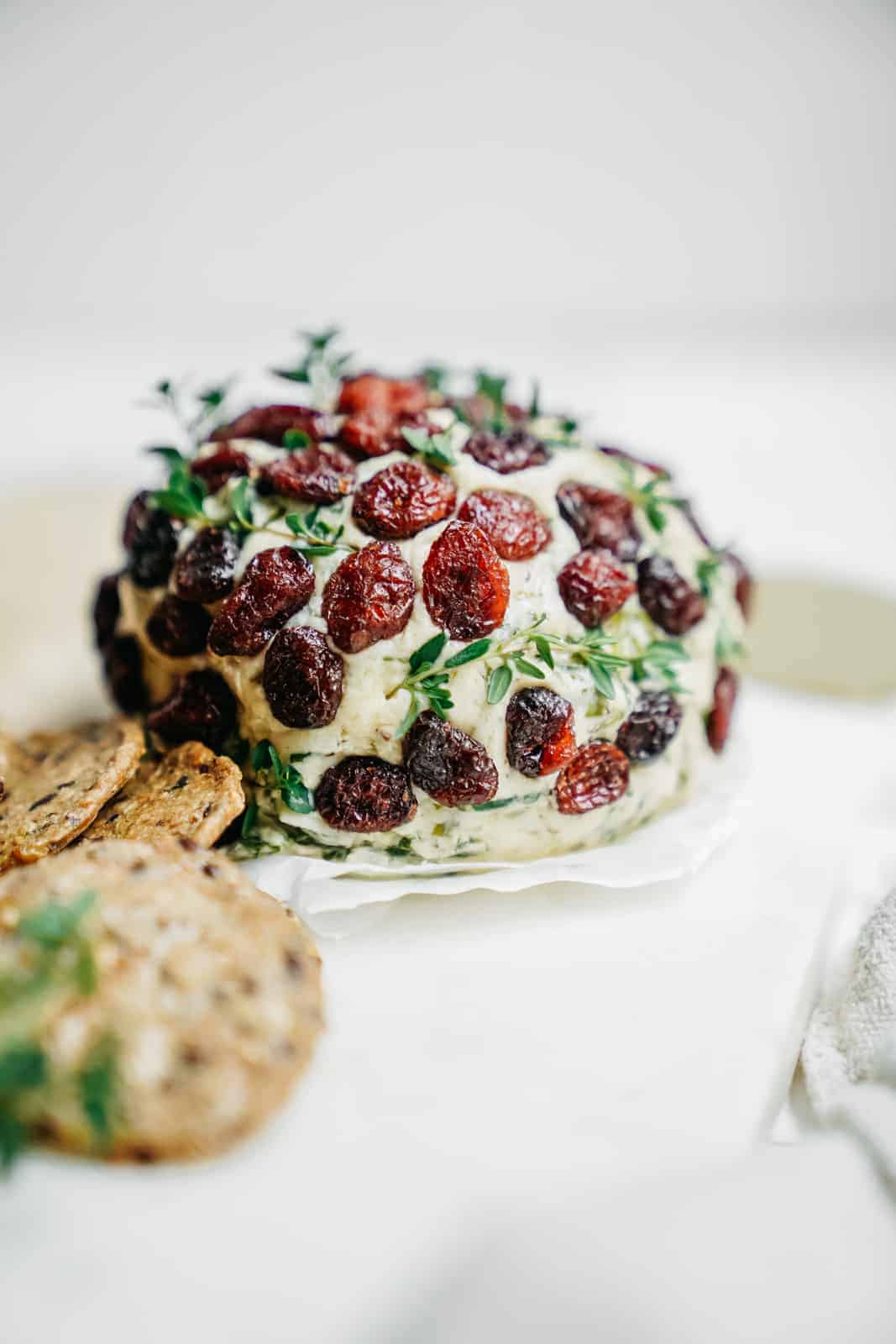 Close-up of a plant-based cheese ball on counter with crackers.