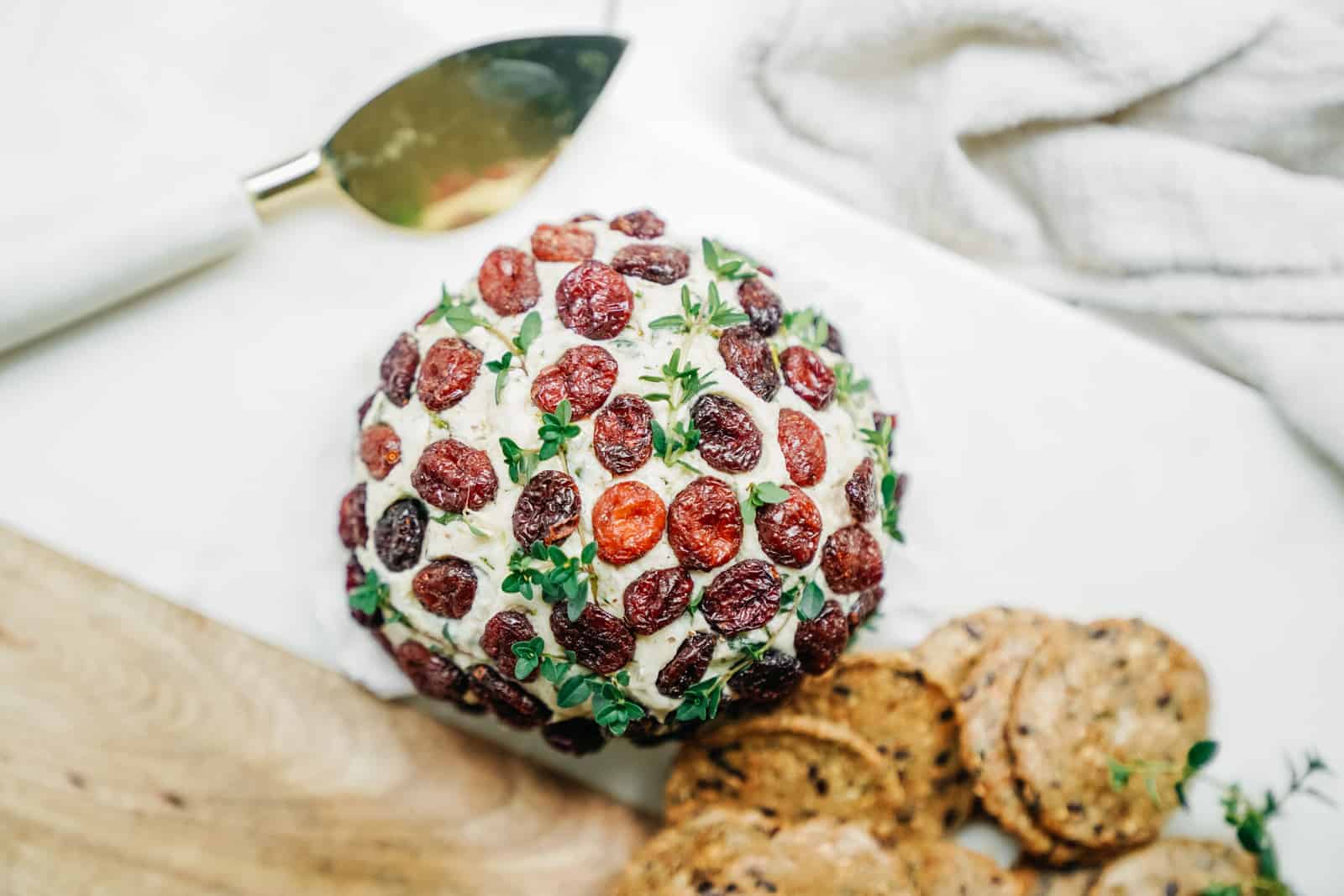 Close-up of a plant-based cheese ball on counter with crackers.