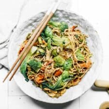 Bowl of Vegan Soba Noodle Salad sitting on counter with chopsticks.