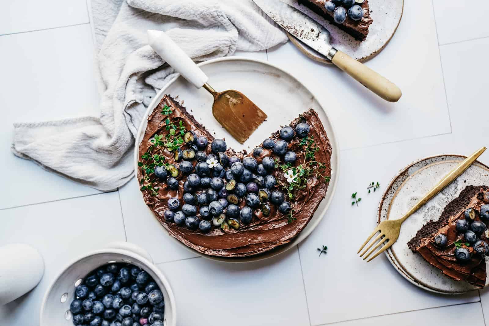 A chocolate cake with blueberries on the counter to demonstrate Maria's top food photography tips.
