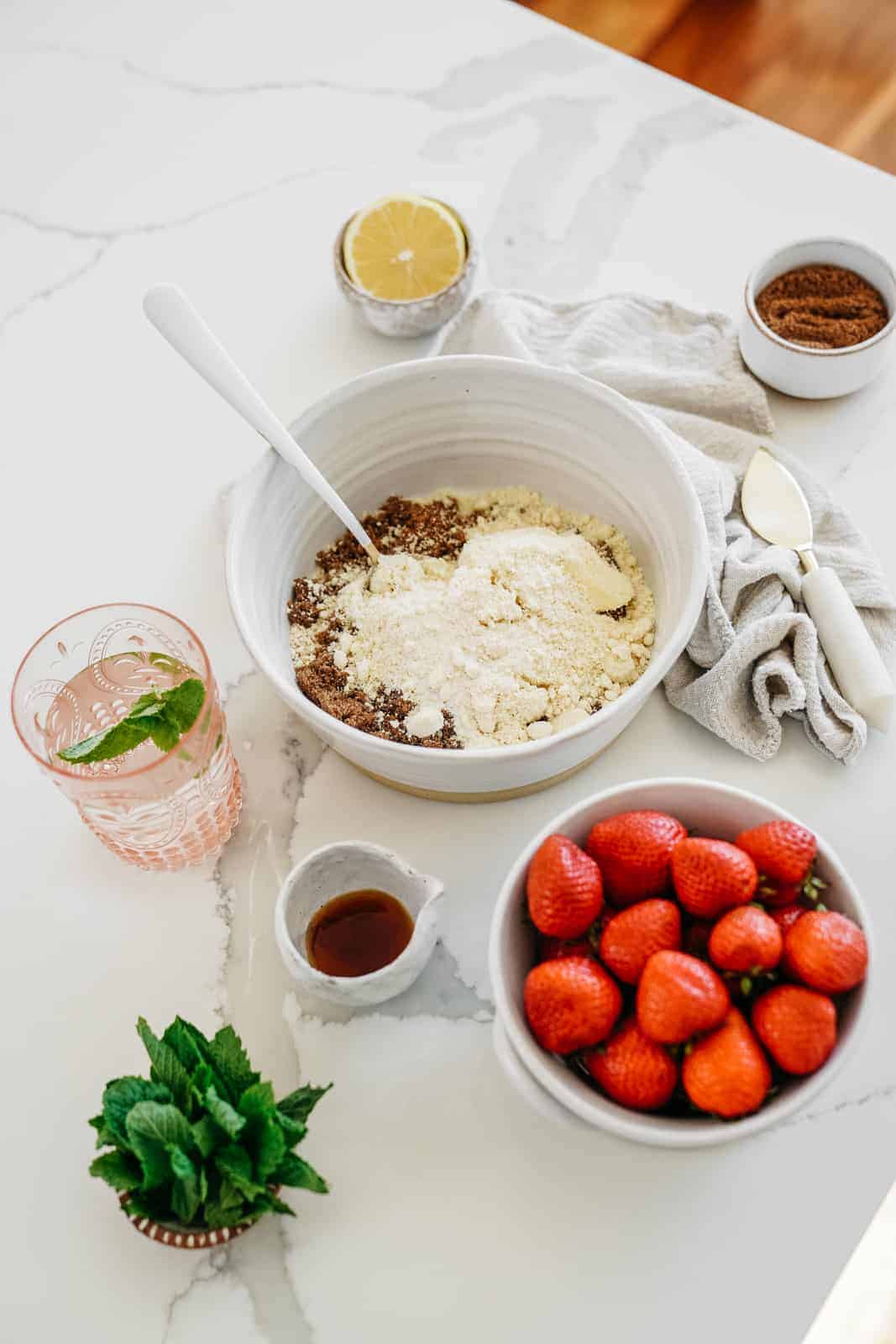 The ingredients for the Crumble Bars laid out on countertop with dry ingredients in the mixing bowl.