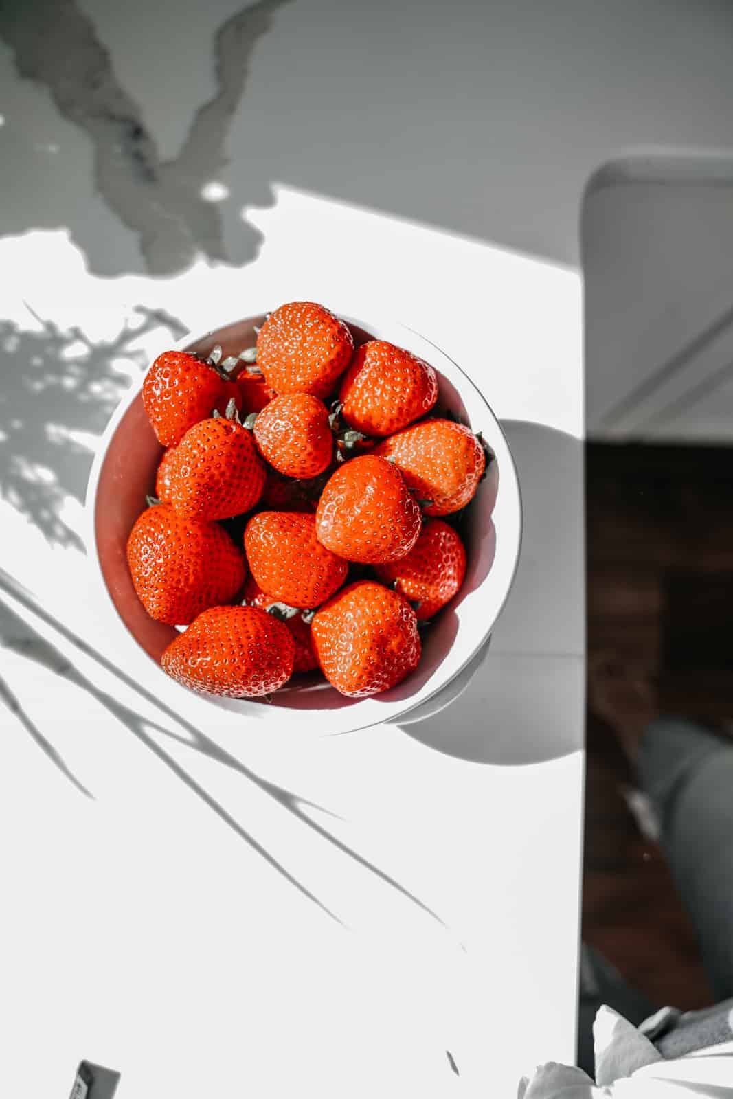 Big bowl of fresh strawberries on counter to demonstrate Maria's top food photography tips.