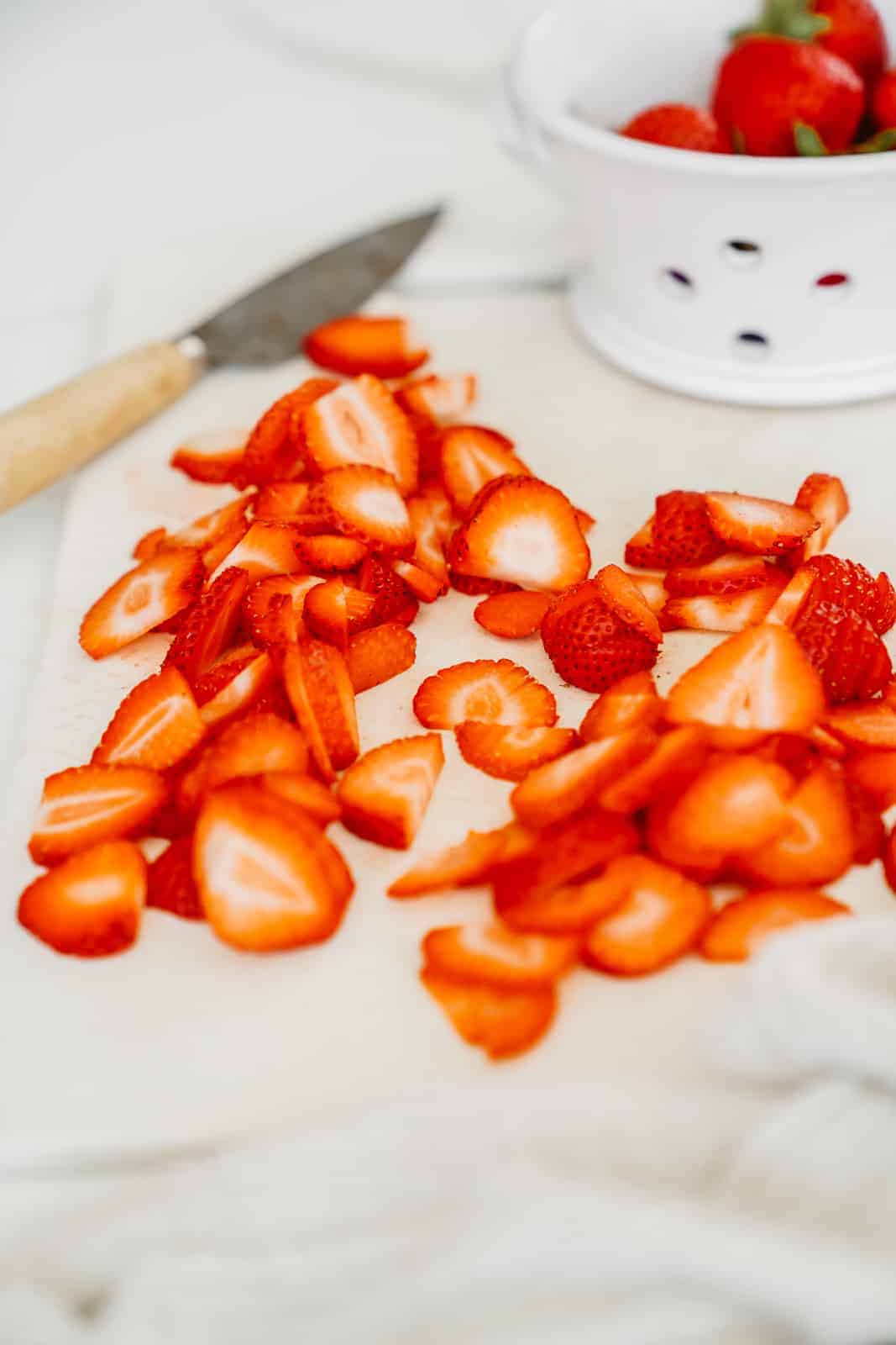 Chopped up strawberries on cutting board ready to go into recipe.