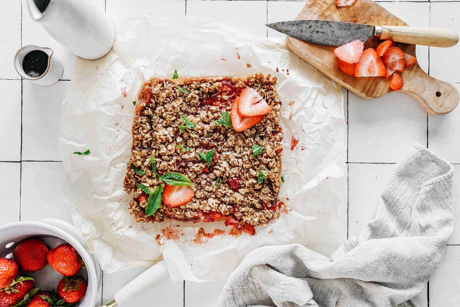 Yummy Vegan Strawberry Crumble Bars on top of parchment paper ready to be eaten.