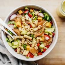 Vegetable Pasta Salad in a dish on a cutting board. A great meal prep vegan pasta recipe.