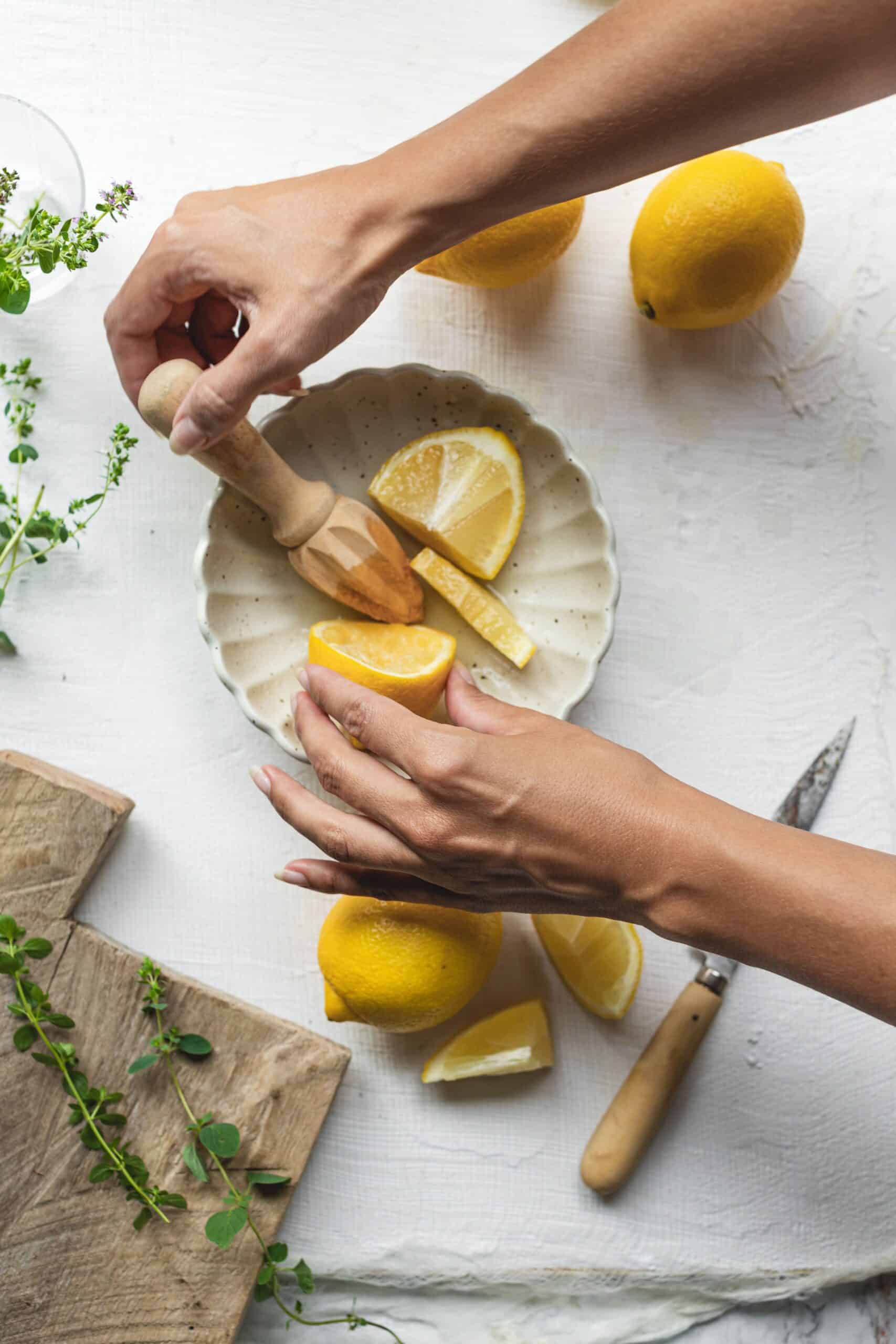 Lemon being muddled in bowl for Greek Salad Dressing Recipe 
