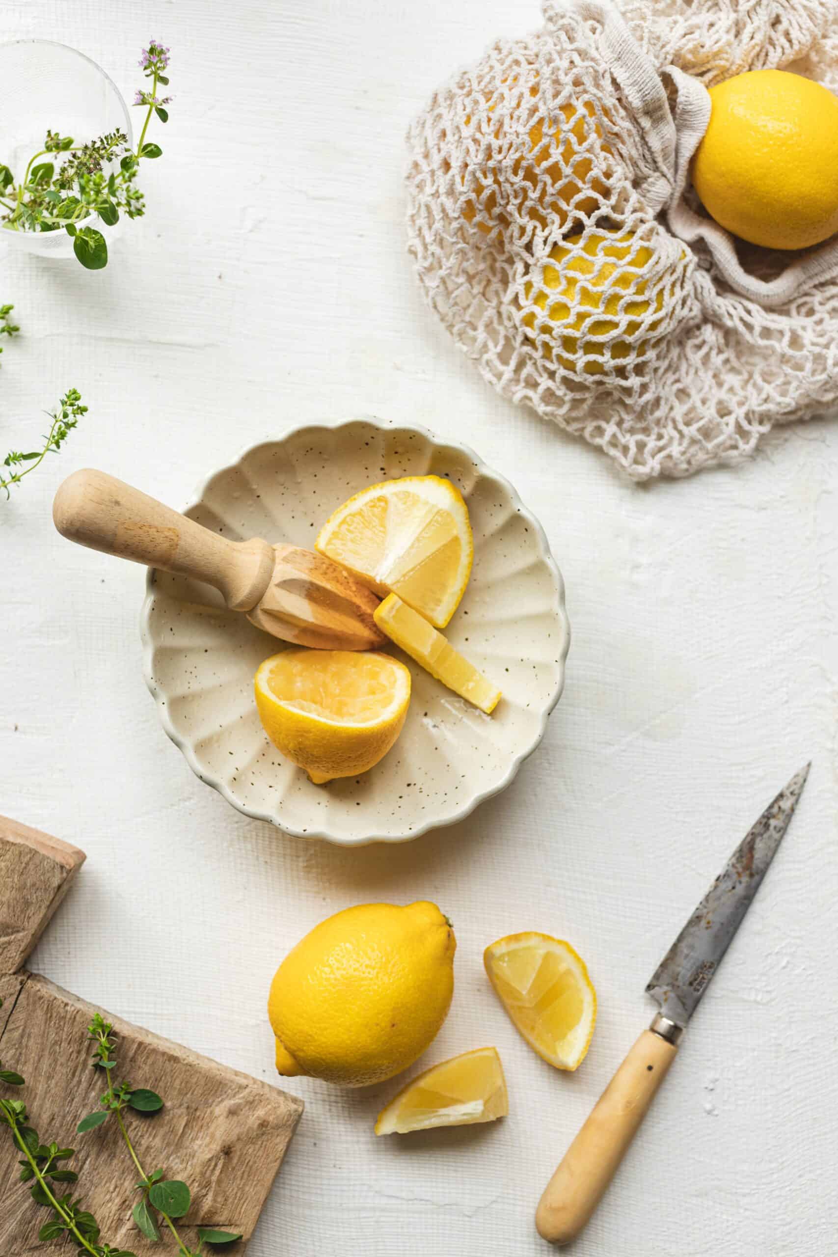 Lemon being muddled in bowl to add to Greek Salad Dressing Recipe.