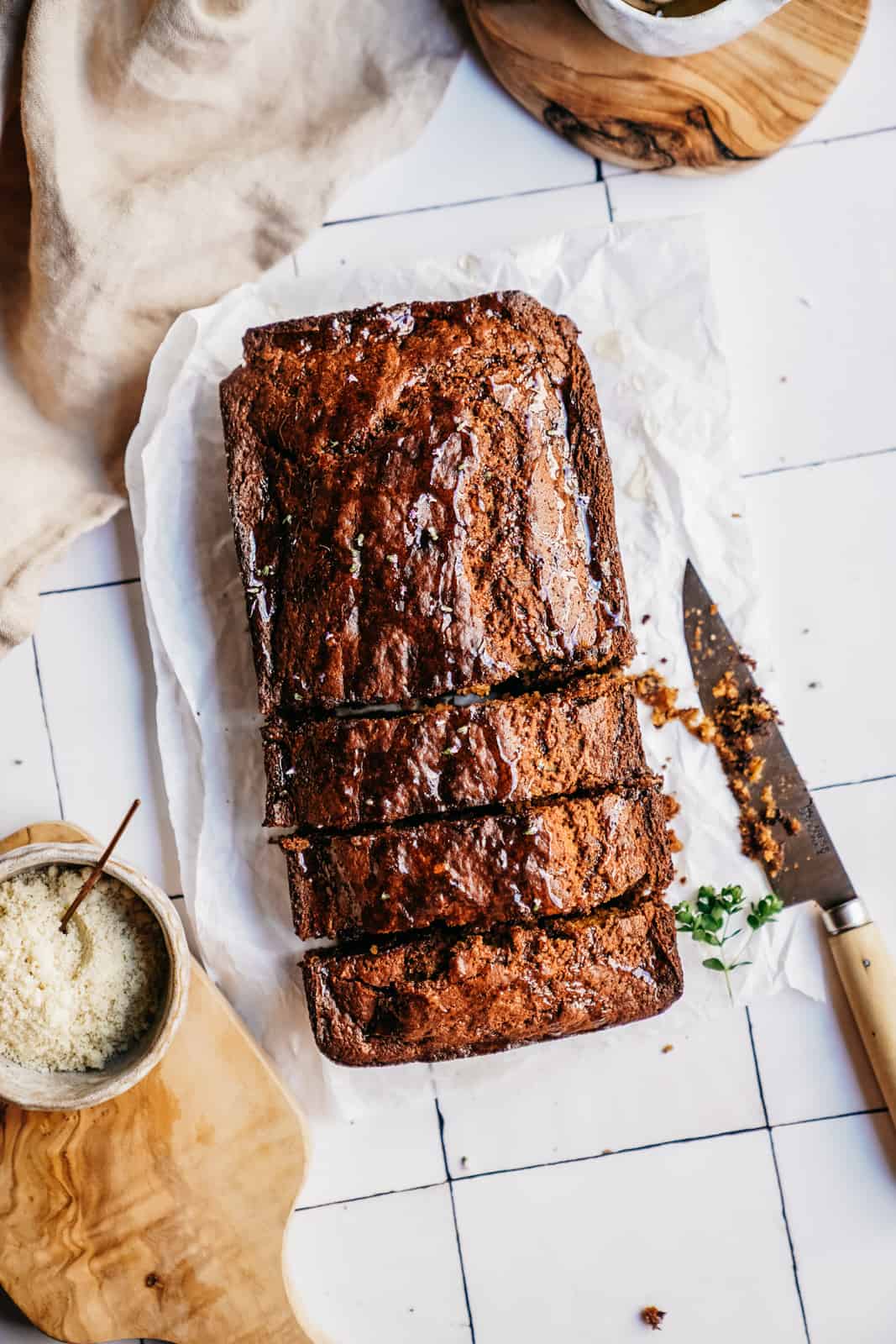 Vegan Zucchini Banana Bread on counter with knife, with a few slices cut out of it.