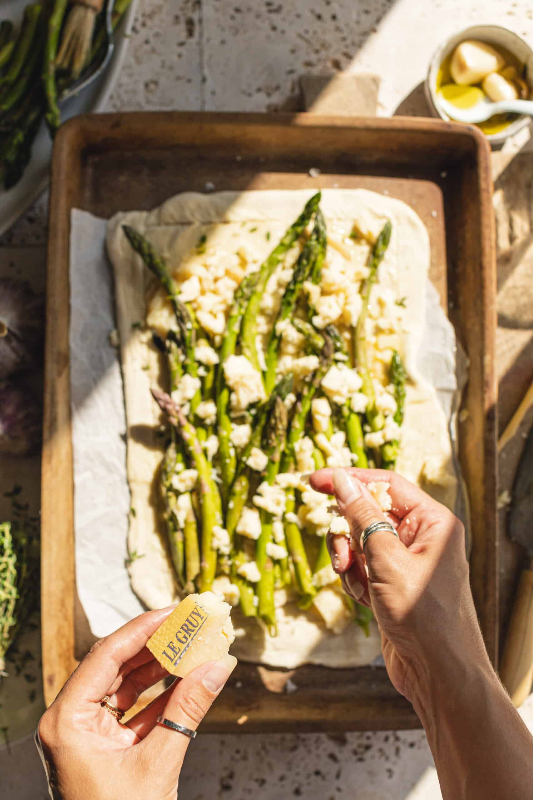 Sprinkling cheese on top of Asparagus and Cheese Tart.