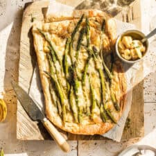 Asparagus and Cheese Tart on cutting board with sun shining through window.