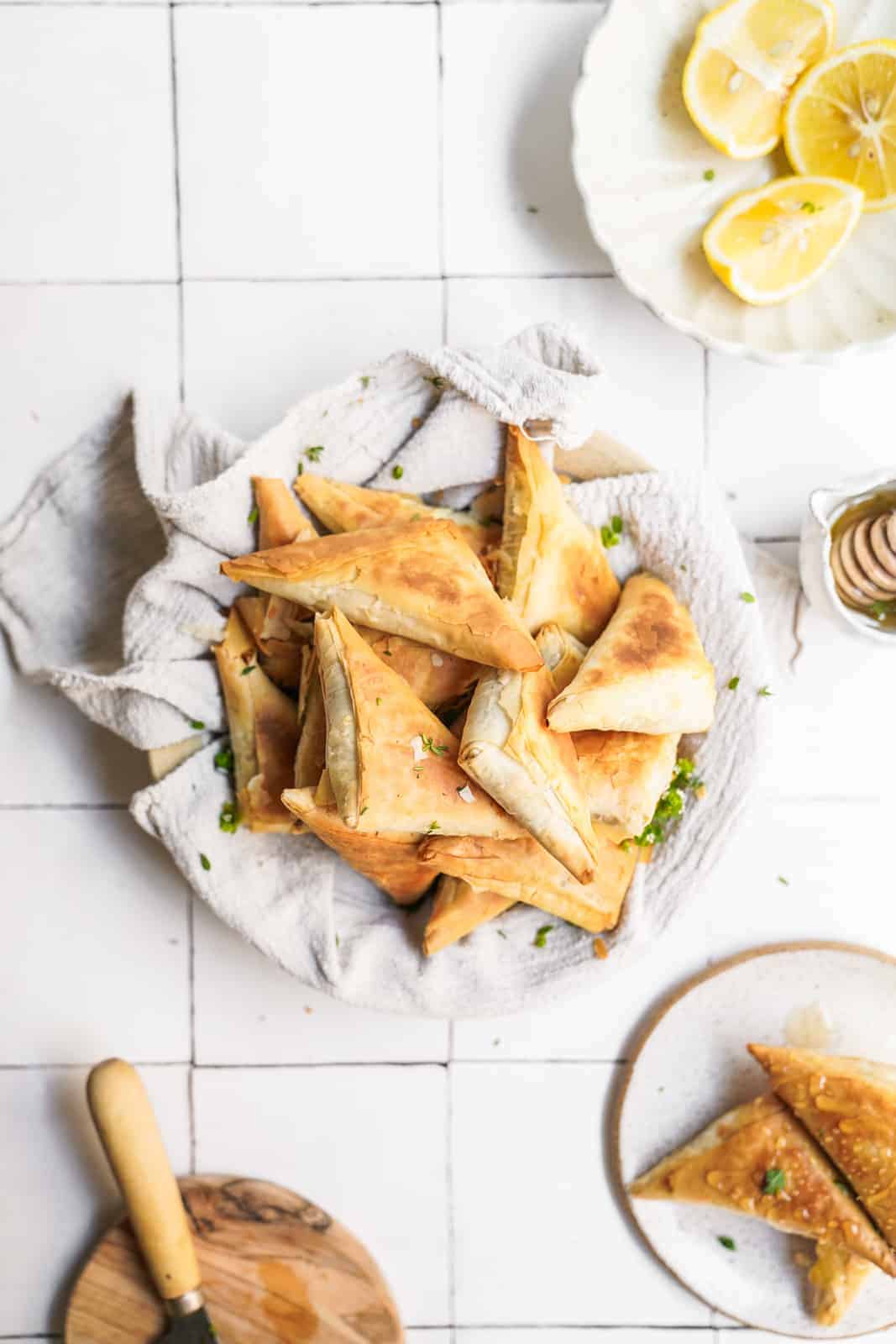 Overhead shot of Vegan Creamy Mushroom Pastry Bites on countertop with ingredients surrounding them.