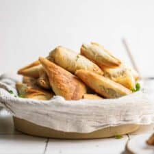 Side angle of spinach pies in a basket