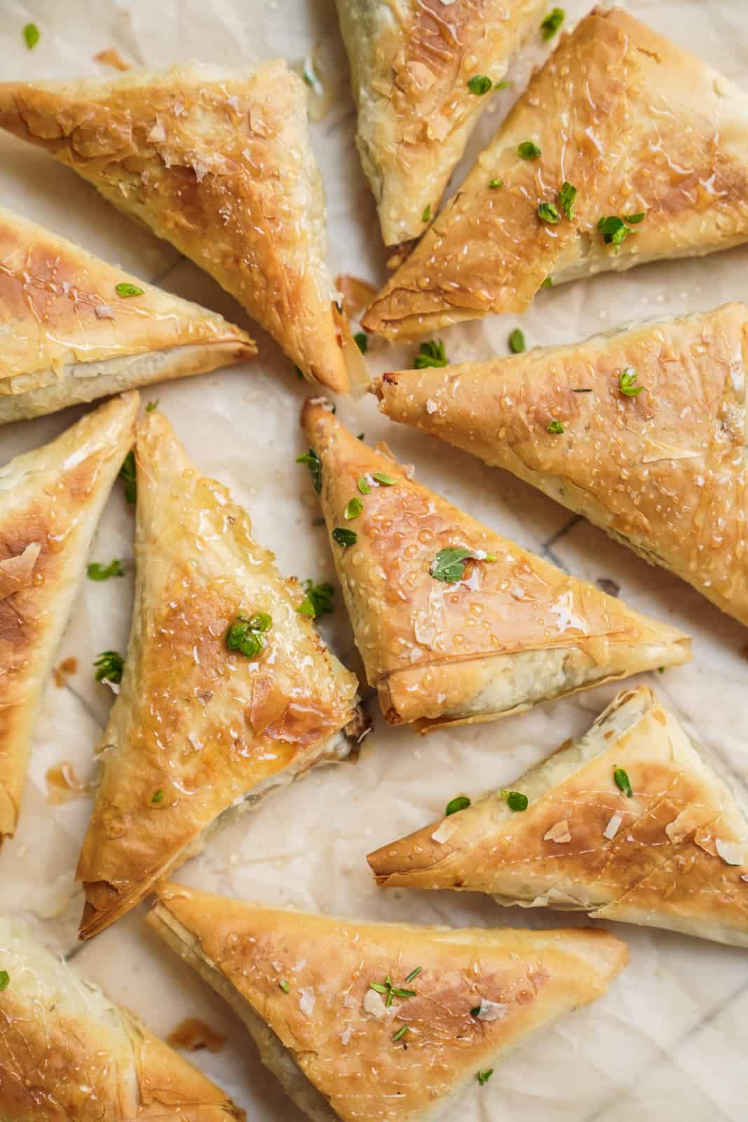Spinach pies cut in triangles on a baking sheet