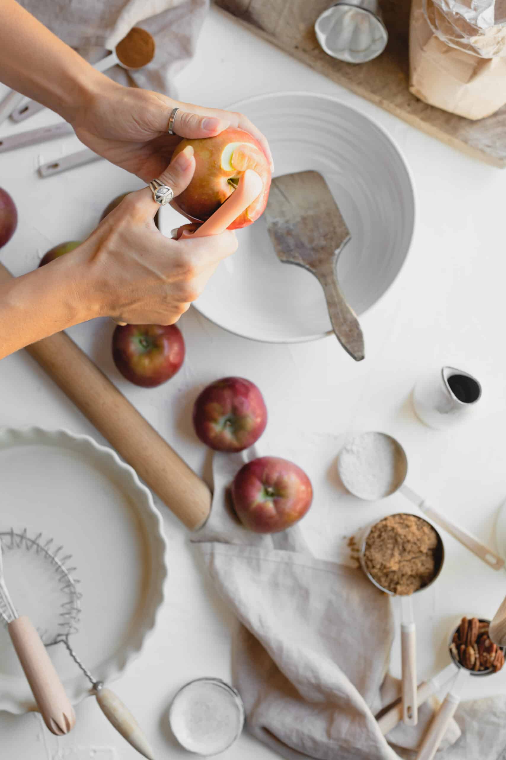 Hand peeling apple to make Vegan Apple Crumble.