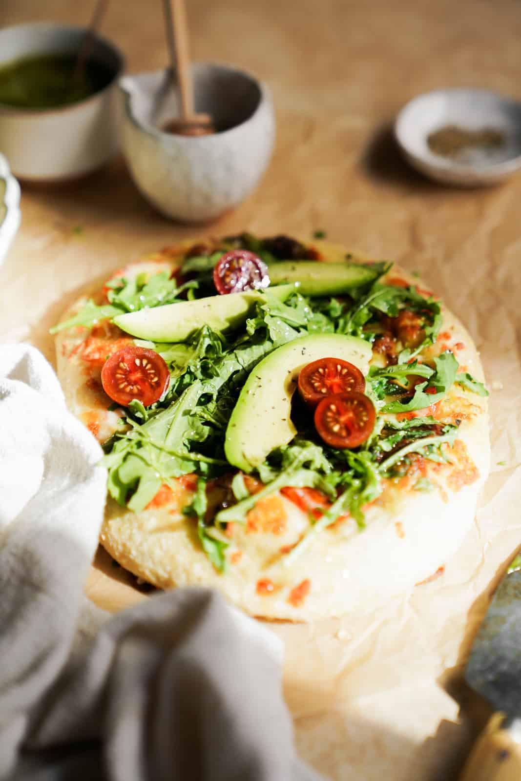 A well lit Vegetarian Breakfast Pizza with gorgeous green toppings