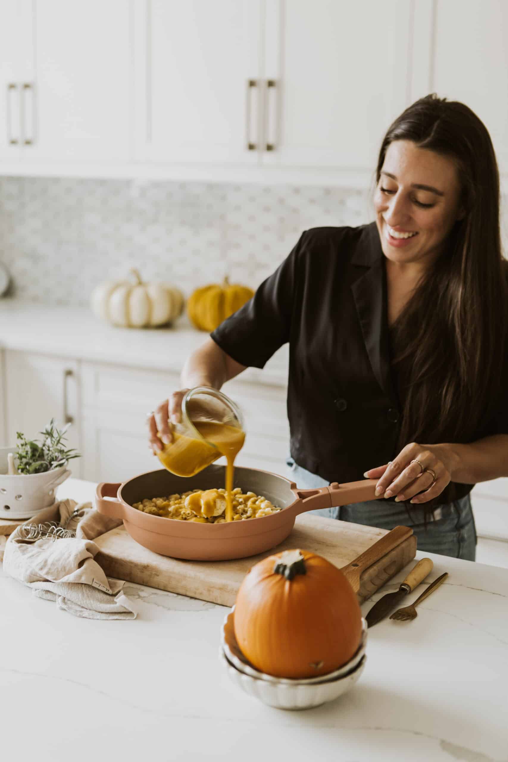 Maria pouring sauce in the Vegan Pumpkin Mac and Cheese