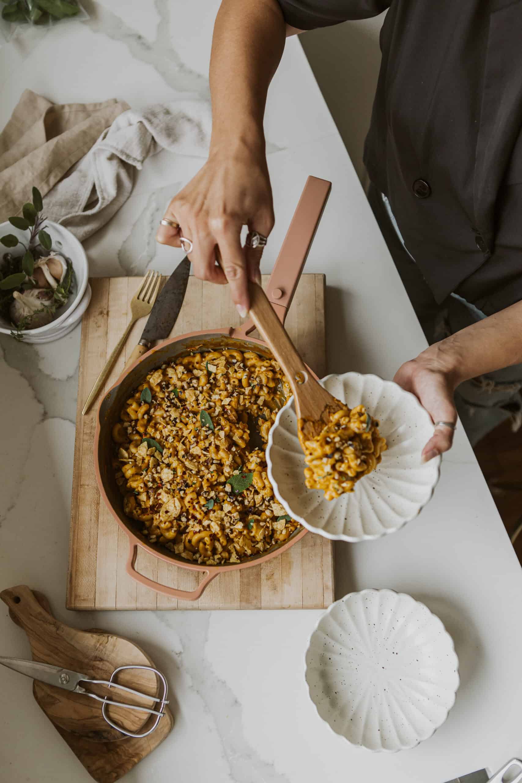 Maria dishing out Vegan Pumpkin Mac and Cheese