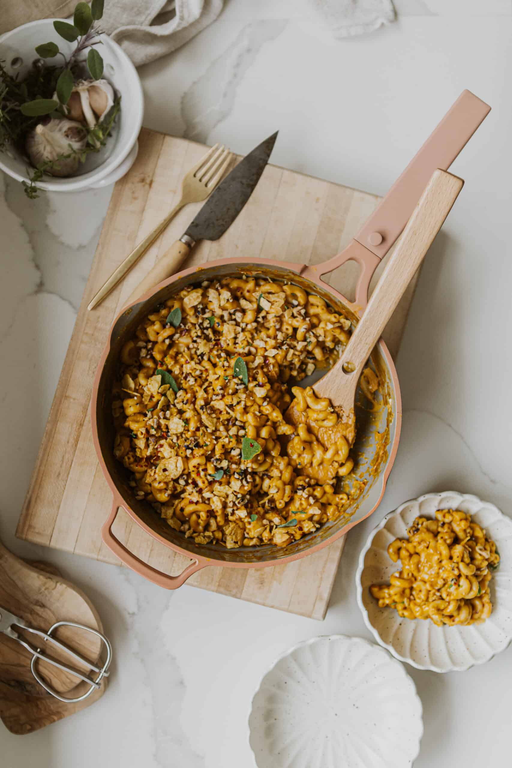 Vegan Pumpkin Mac and Cheese on cutting board in pot with spoon