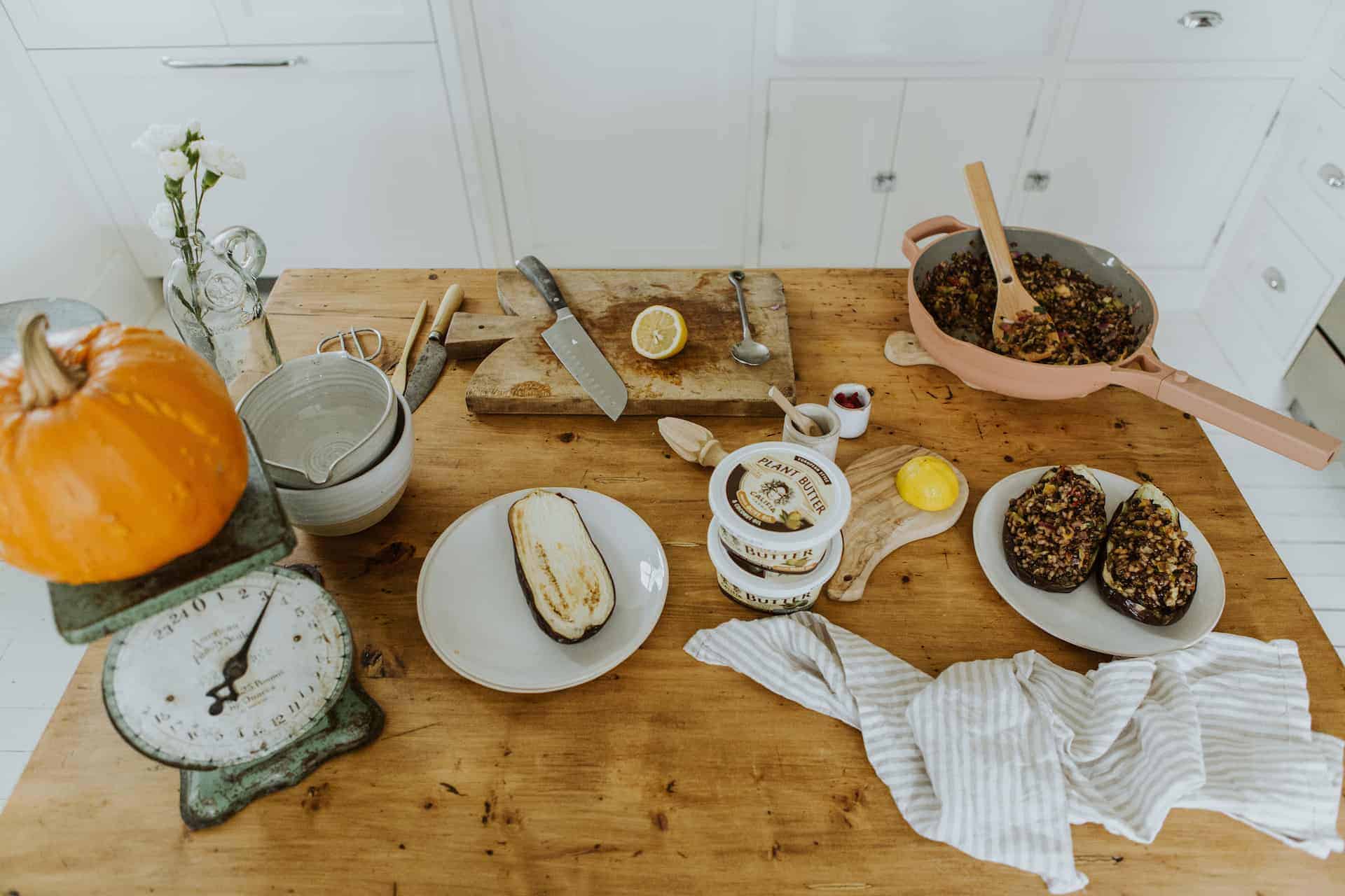 Kitchen set-up with Califia Farms plant butter next to stuffed eggplant and the ingredients to make it.