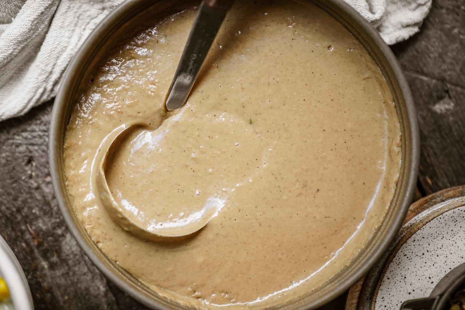 Pot of vegan gravy with ladle in it.