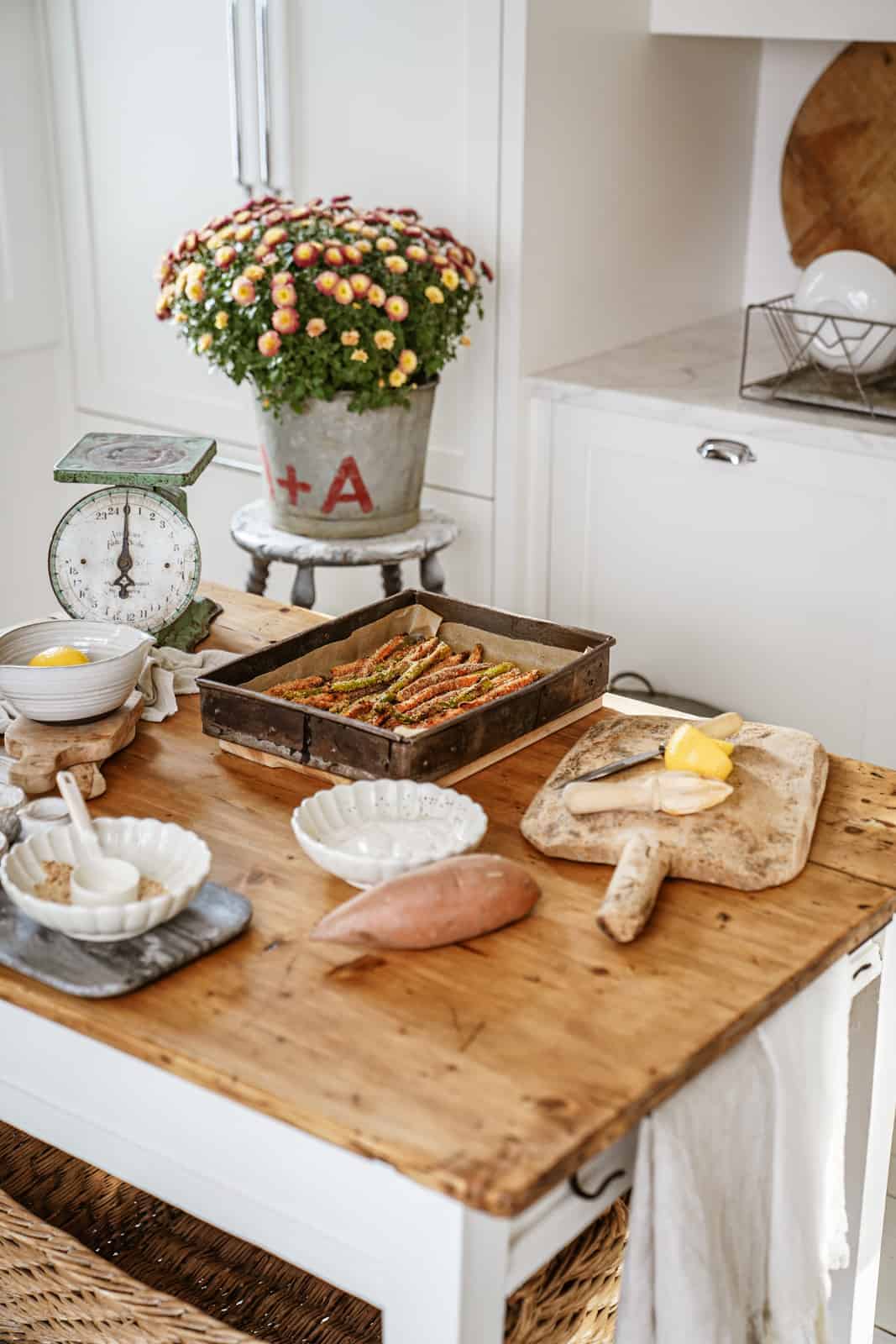 Sweet potato & asparagus fries in a baking dish on a countertop full of ingredients.