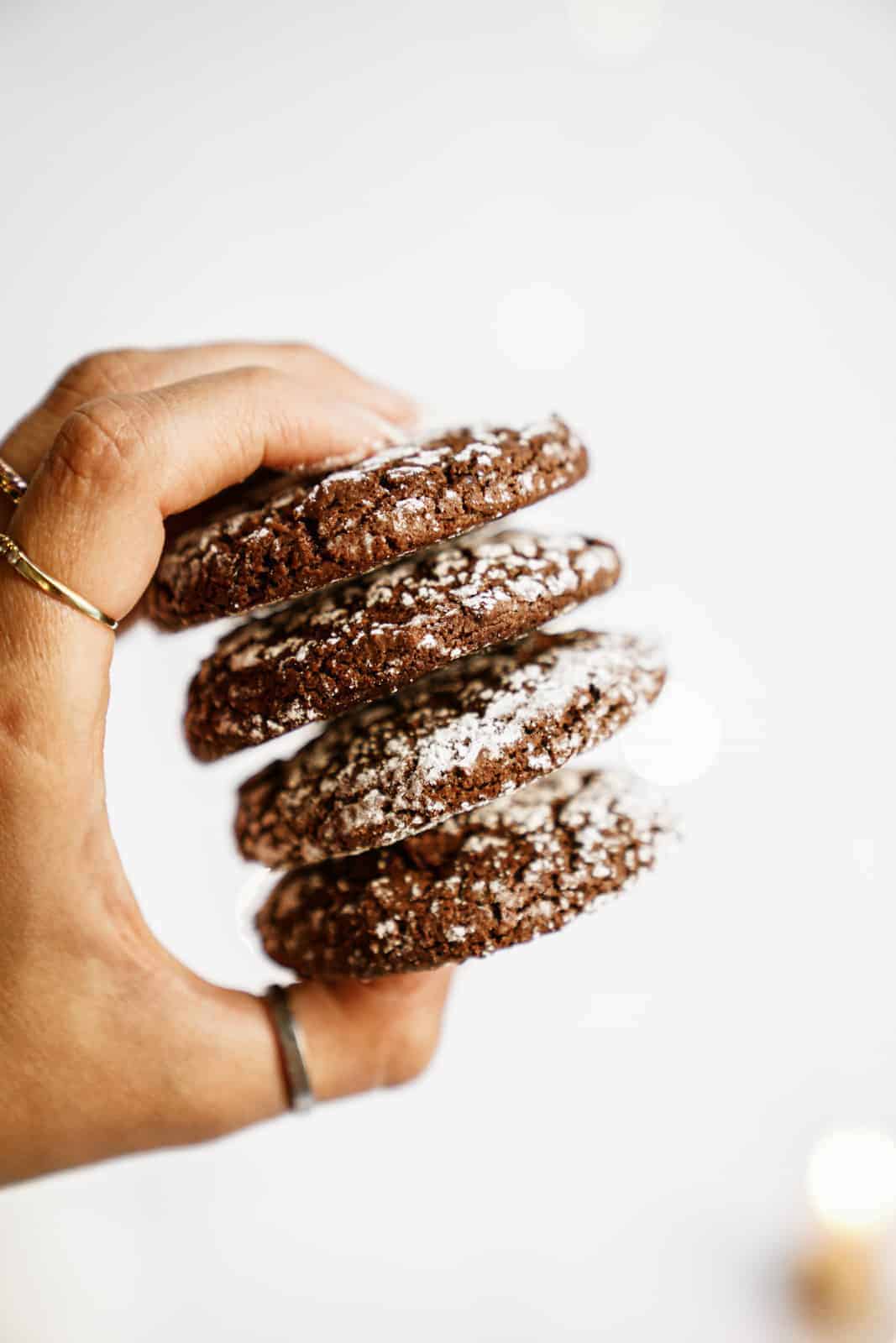 Hand holding a stack of the Chocolate Crinkle Cookie Recipe cookies.