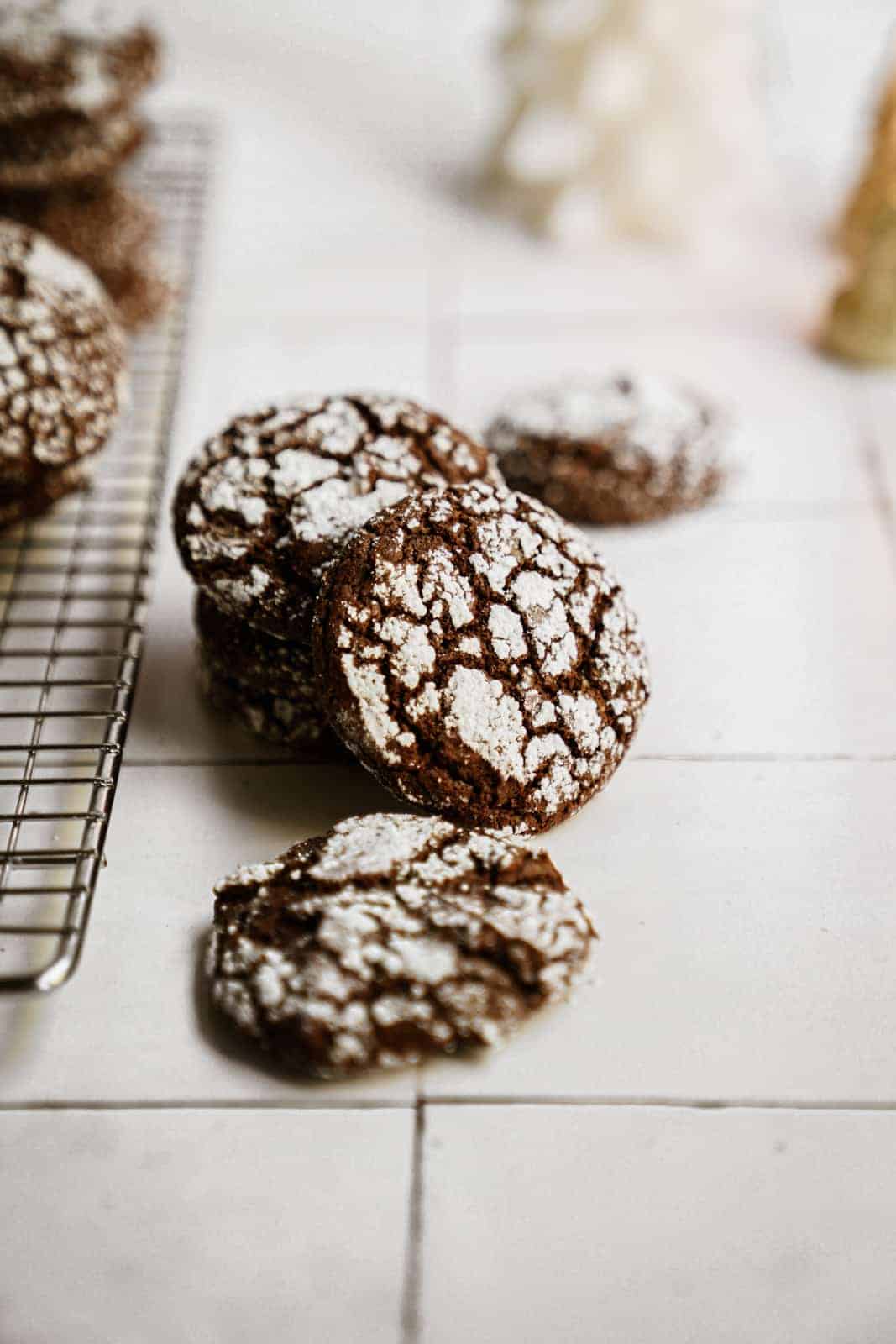 Cookies from my Chocolate Crinkle Cookie Recipe scattered on white countertop.