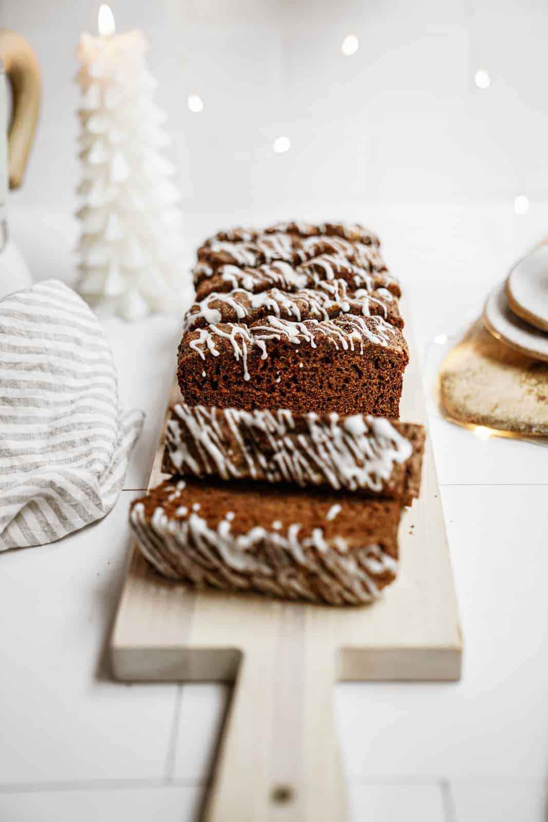 Vegan gingerbread loaf sliced on cutting board.