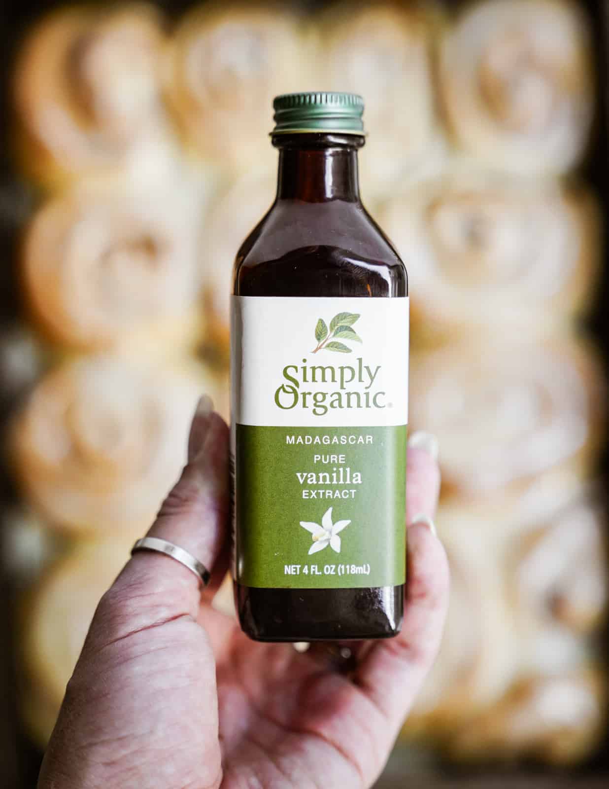 Hand holding Simply Organic Pure Vanilla Extract used in vegan cinnamon buns