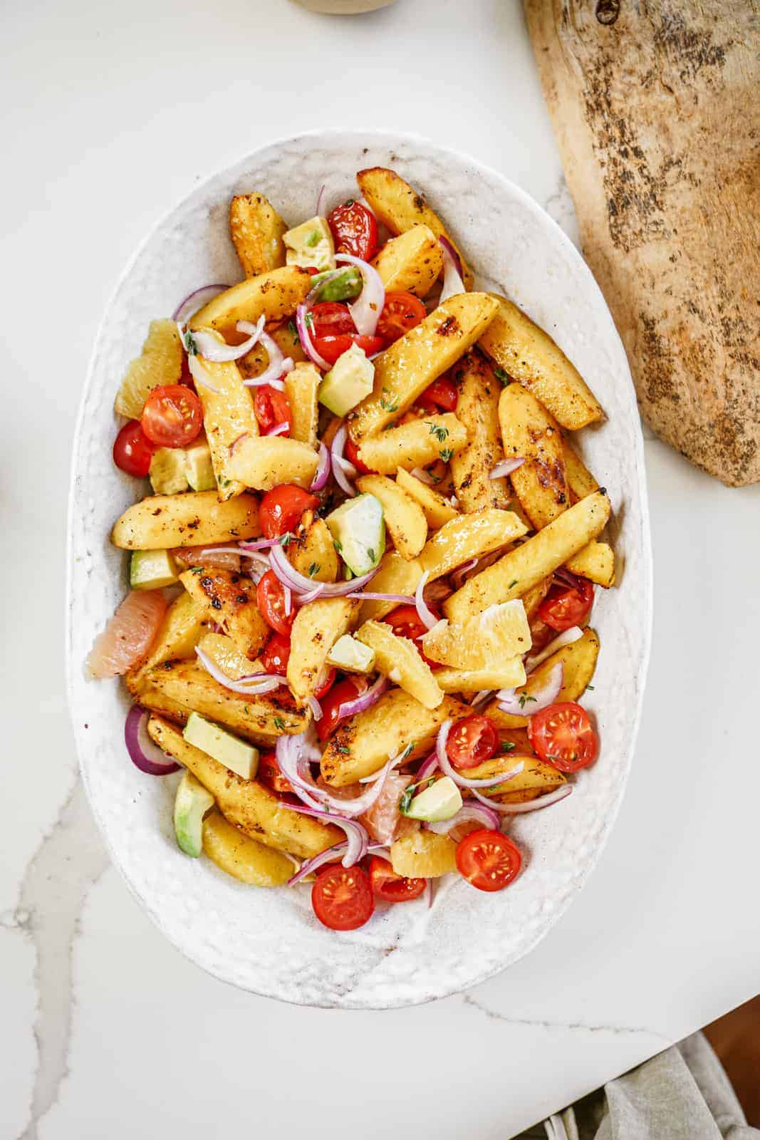 Serving dish filled with colorful vegan roasted potato salad.