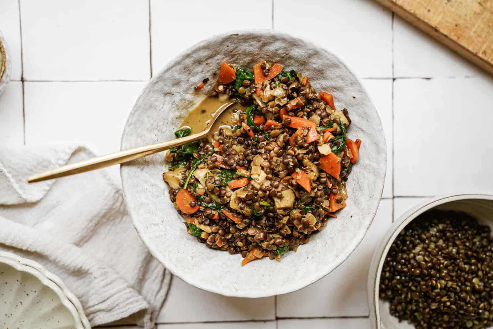 Lentils with Spinach in serving dish with spoon in the bowl.