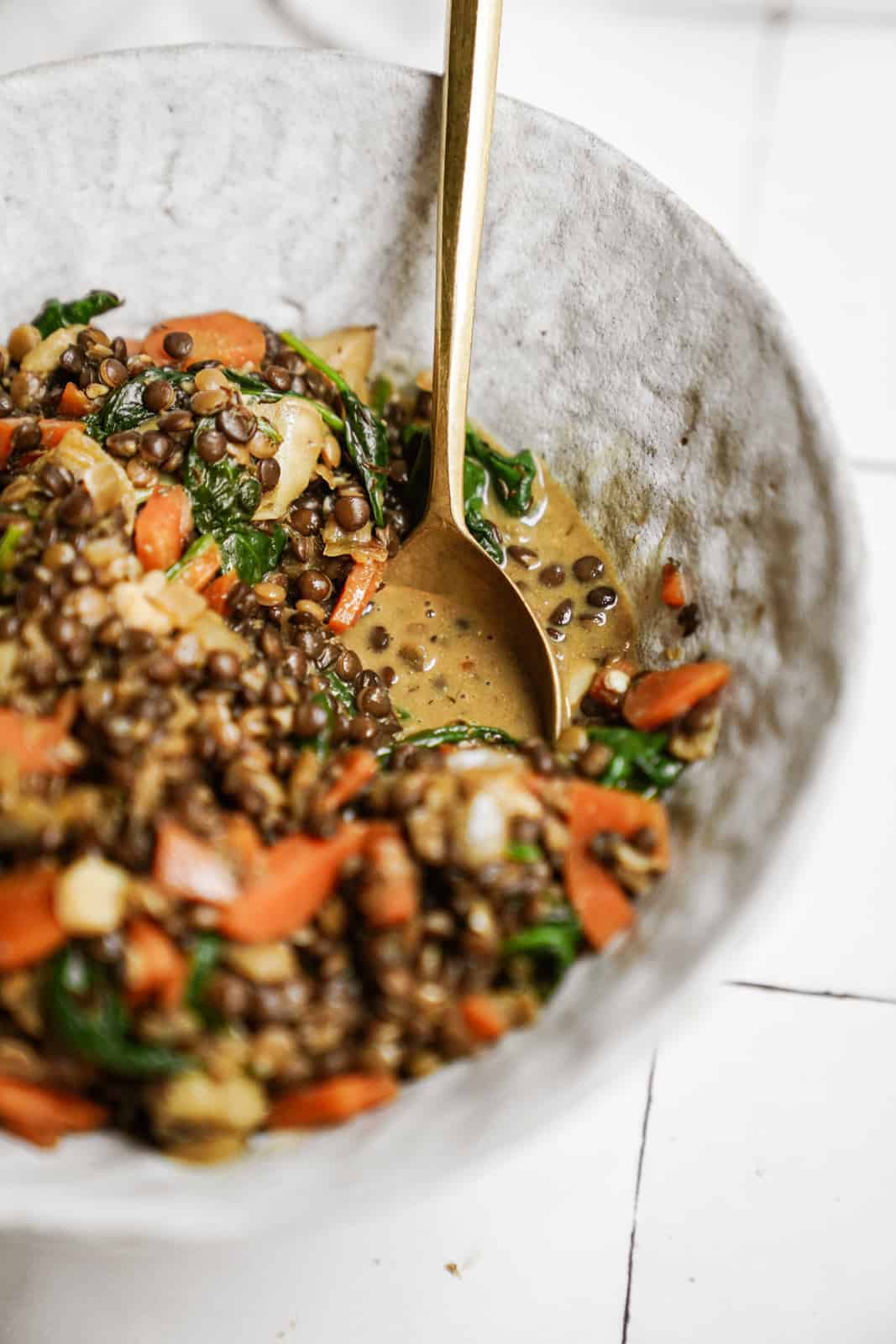 Lentils with Spinach in serving dish with spoon in the bowl.