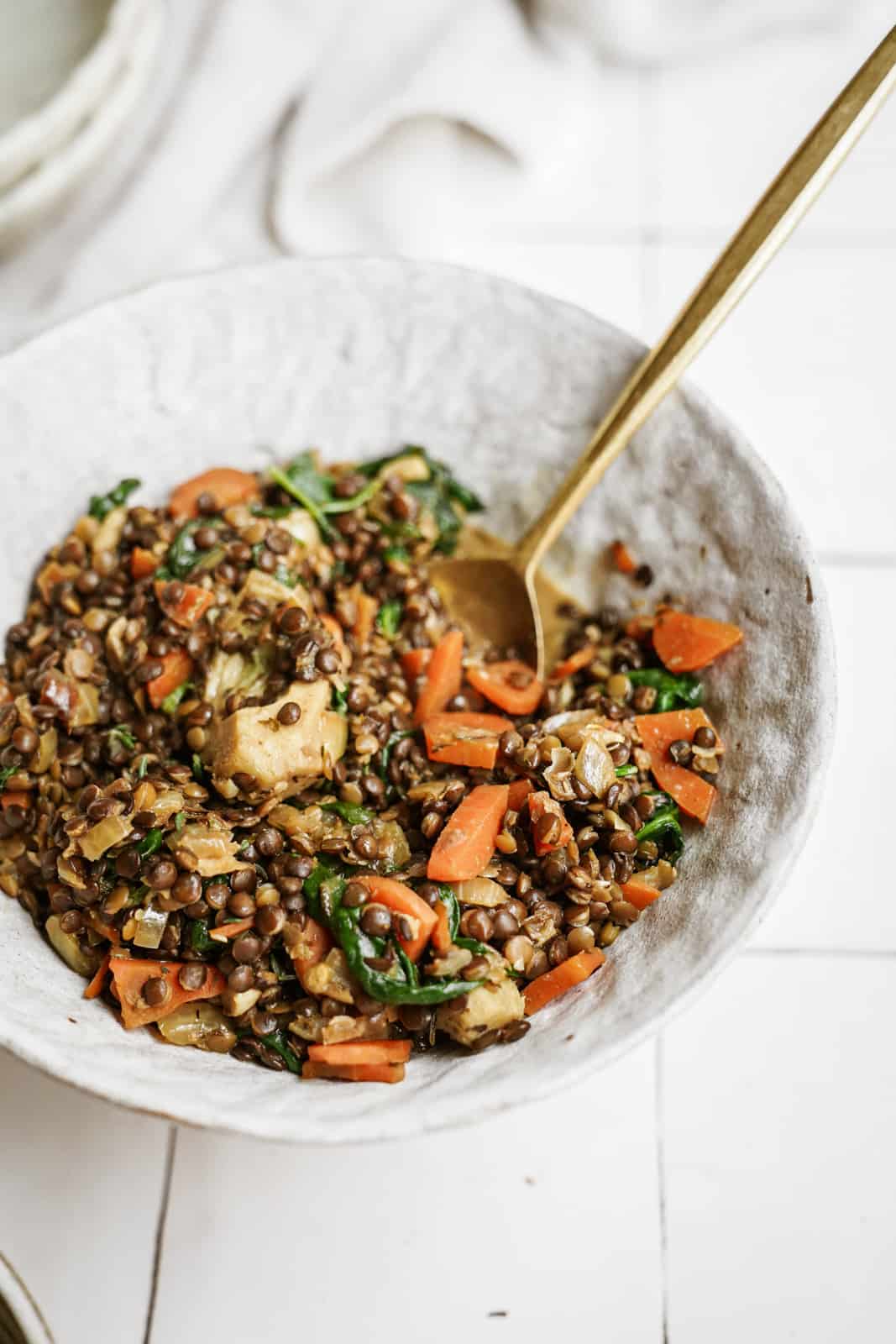 Lentils with Spinach in serving dish with spoon in the bowl