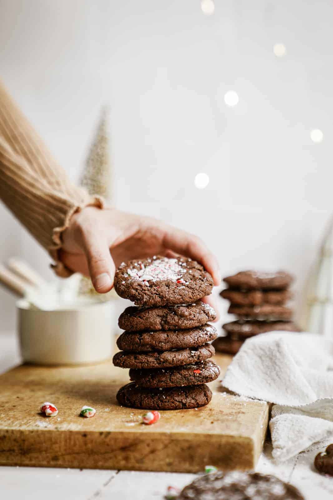 Vegan Chocolate Peppermint Cookies in stack with hand reaching for one.
