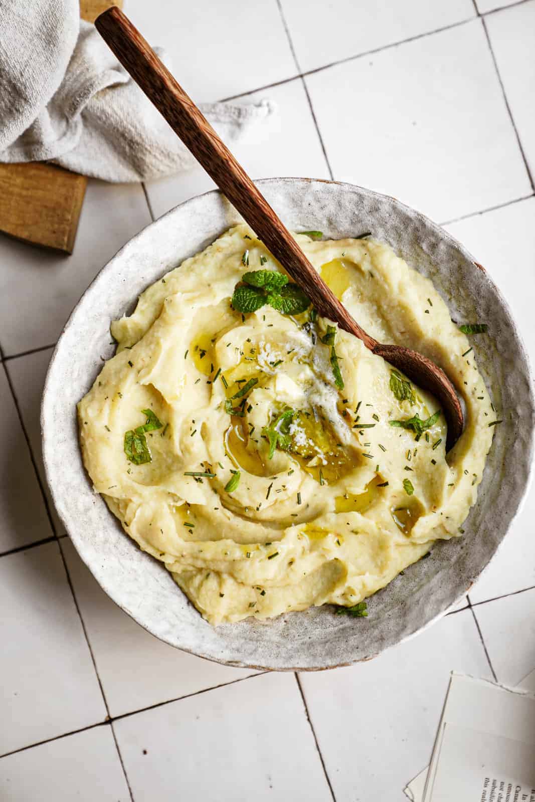 Parsnip Mash in serving bowl with big wooden serving spoon.