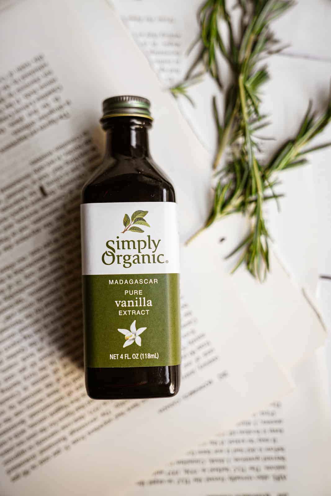 Simply Organics Pure Vanilla Extract laying on top of recipe with rosemary sprigs.