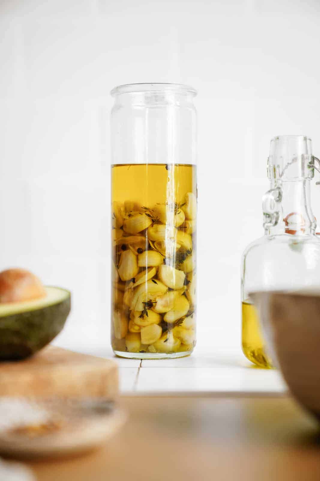 Jar of garlic confit next to jar of infused olive oil.