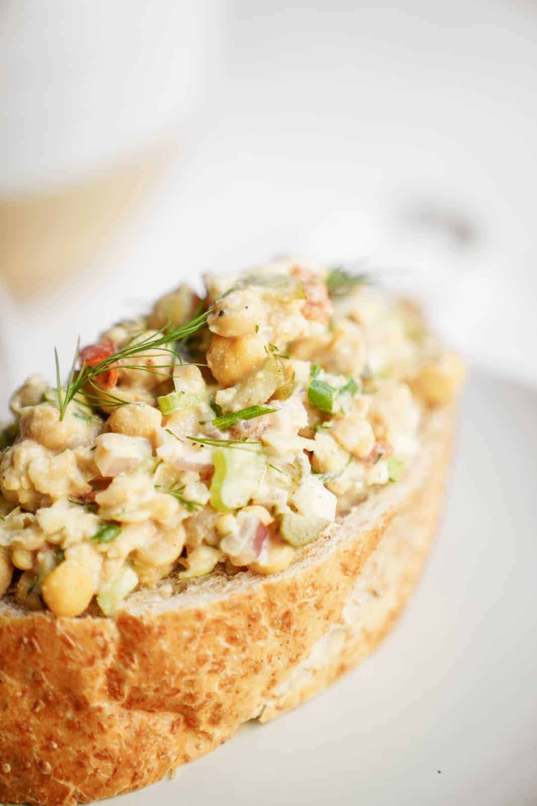 Mashed Chickpea Salad sitting on a piece of bread on a plate